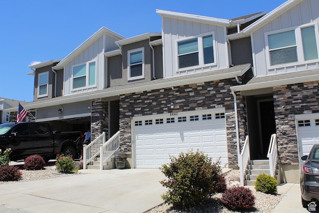 4442 W Hill Shadow Way S, Herriman, UT 84096 - view of front facade featuring board and batten siding, an attached garage, stone siding, and concrete driveway