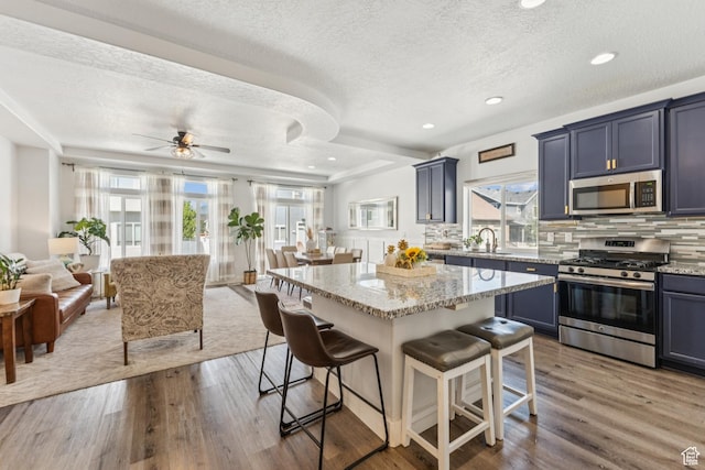 1076 S Meadow Walk Ln, Heber City, UT 84032 - kitchen featuring stainless steel appliances, a breakfast bar area, a textured ceiling, plenty of natural light, and open floor plan
