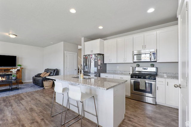 1017 W Coyote Gulch Way S Unit 117, Bluffdale, UT 84065 - kitchen featuring appliances with stainless steel finishes, open floor plan, wood finished floors, white cabinetry, and recessed lighting
