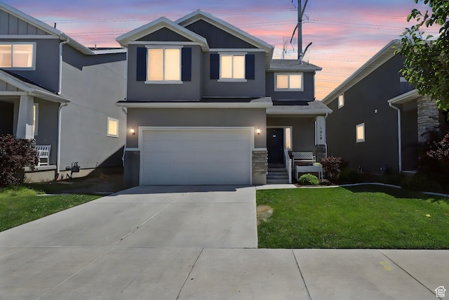1017 W Coyote Gulch Way S Unit 117, Bluffdale, UT 84065 - view of front of property featuring a yard, stucco siding, a garage, concrete driveway, and board and batten siding