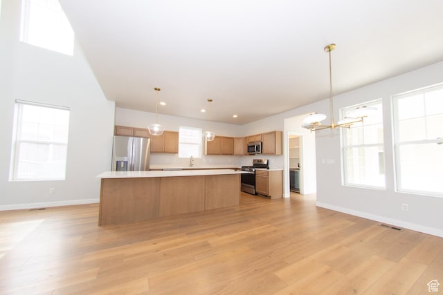 11511 S Pebble Pond Rd, South Jordan, UT 84009 - kitchen featuring appliances with stainless steel finishes, a chandelier, light countertops, a kitchen island, and light wood-type flooring