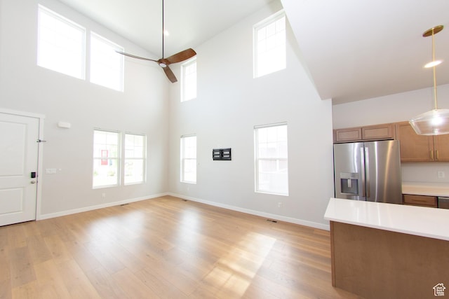 11511 S Pebble Pond Rd, South Jordan, UT 84009 - unfurnished living room featuring a high ceiling, light wood-type flooring, and ceiling fan