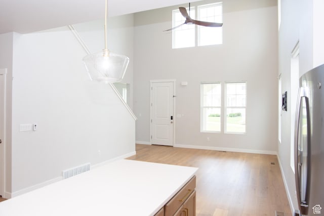 11511 S Pebble Pond Rd, South Jordan, UT 84009 - kitchen featuring freestanding refrigerator, light wood-style flooring, healthy amount of natural light, and a towering ceiling