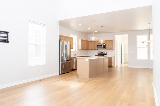 11511 S Pebble Pond Rd, South Jordan, UT 84009 - kitchen featuring stainless steel appliances, light countertops, a kitchen island, light wood-style floors, and pendant lighting