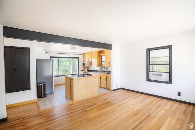 8646 W Florence Dr, Magna, UT 84044 - kitchen featuring light brown cabinets, light wood-type flooring, appliances with stainless steel finishes, and a kitchen island