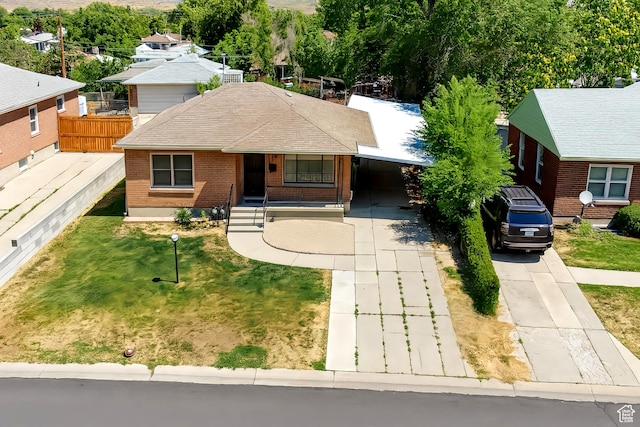 8646 W Florence Dr, Magna, UT 84044 - view of front of house featuring concrete driveway, brick siding, an attached carport, and roof with shingles
