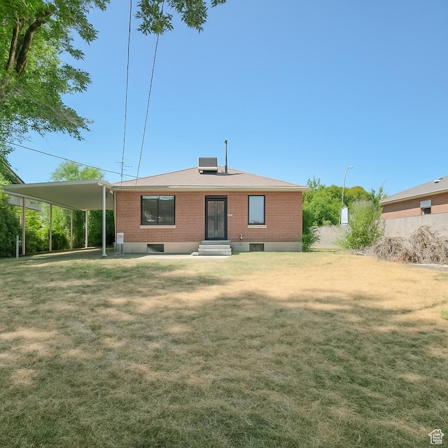 8646 W Florence Dr, Magna, UT 84044 - back of house featuring a yard, entry steps, brick siding, and a carport