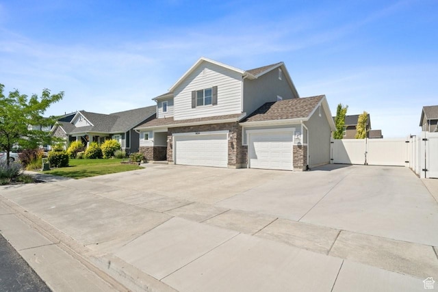 3634 S Creek Side Ln, Syracuse, UT 84075 - view of front facade featuring a gate, driveway, an attached garage, and stone siding