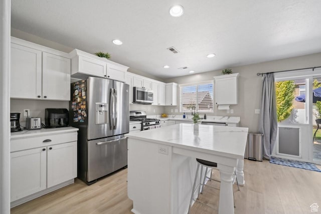 3634 S Creek Side Ln, Syracuse, UT 84075 - kitchen featuring stainless steel appliances, light wood-style floors, white cabinetry, a center island, and recessed lighting