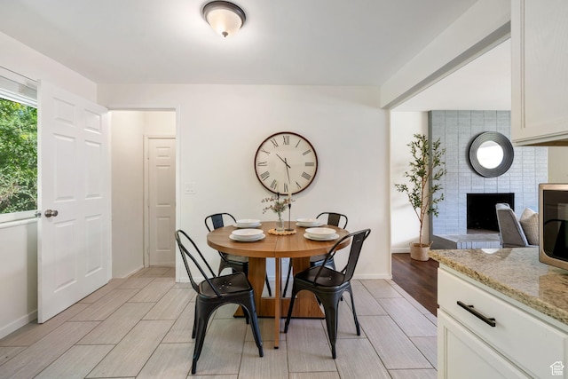 5726 S Highland Dr E, Holladay, UT 84121 - dining room featuring wood tiled floors and a fireplace