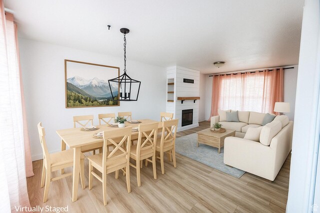4518 Silver Spur Way, Eagle Mountain, UT 84005 - dining room featuring light wood-style flooring and a fireplace