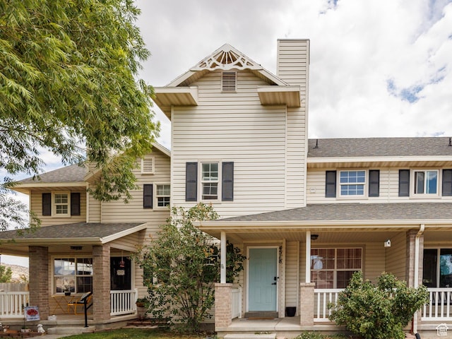 4518 Silver Spur Way, Eagle Mountain, UT 84005 - townhome / multi-family property featuring covered porch, a chimney, and a shingled roof