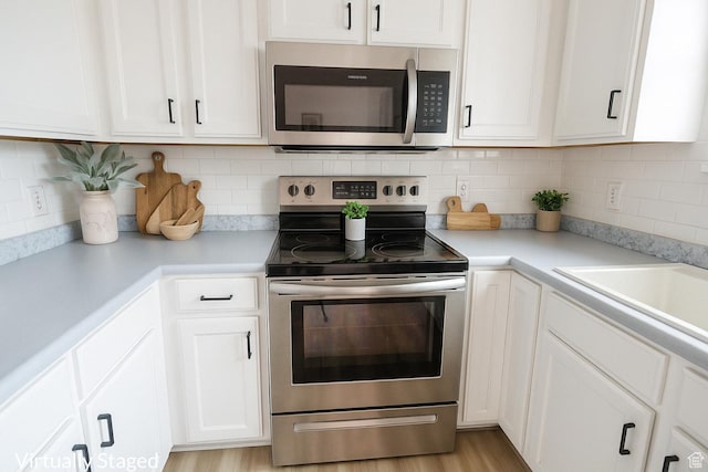 4518 Silver Spur Way, Eagle Mountain, UT 84005 - kitchen featuring stainless steel appliances, white cabinetry, light countertops, and tasteful backsplash