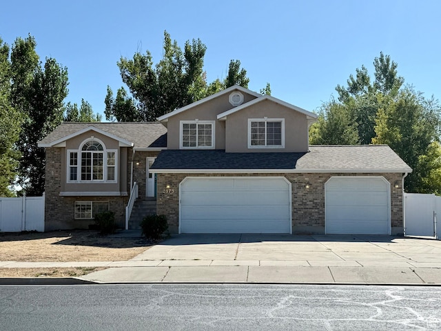 2573 W Remuda Dr, Farr West, UT 84404 - view of front of home featuring driveway, a garage, a shingled roof, and brick siding