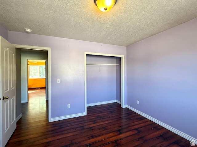 2573 W Remuda Dr, Farr West, UT 84404 - unfurnished bedroom with dark wood-type flooring, a textured ceiling, and a closet