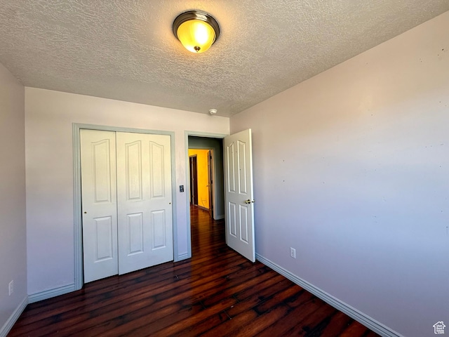 2573 W Remuda Dr, Farr West, UT 84404 - unfurnished bedroom with dark wood finished floors, a closet, and a textured ceiling