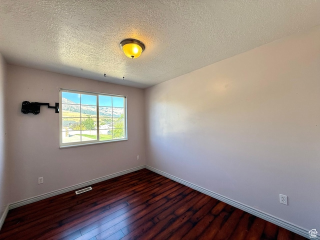2573 W Remuda Dr, Farr West, UT 84404 - empty room with dark wood finished floors and a textured ceiling