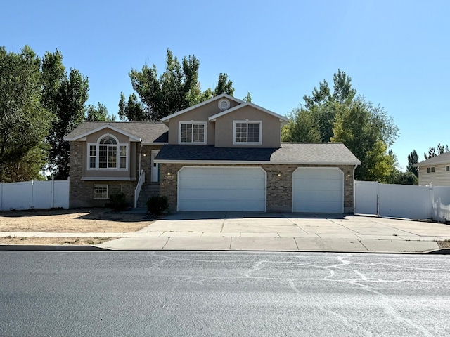 2573 W Remuda Dr, Farr West, UT 84404 - view of front of home with concrete driveway, brick siding, a garage, and a shingled roof
