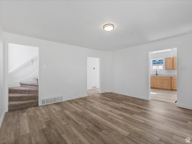 963 E 23rd St, Ogden, UT 84401 - unfurnished living room with light wood finished floors and stairs