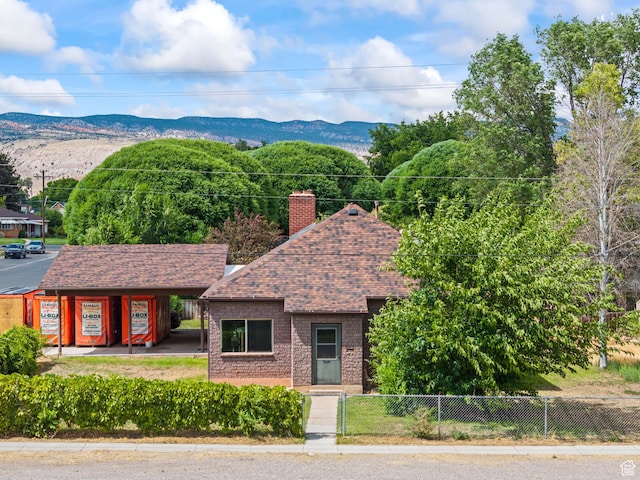 407 E 200 N, Richfield, UT 84701 - view of front facade with a fenced front yard, a shingled roof, a chimney, and a mountain view