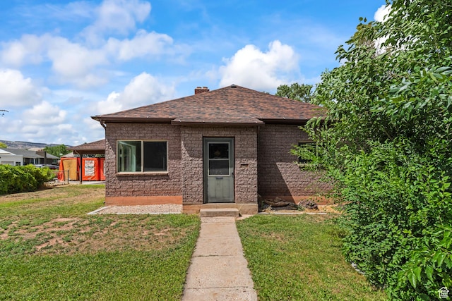 407 E 200 N, Richfield, UT 84701 - view of front facade featuring a front lawn, a chimney, and a shingled roof