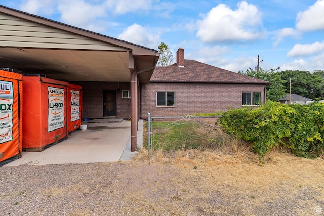 407 E 200 N, Richfield, UT 84701 - view of property exterior featuring a chimney, roof with shingles, an attached carport, and brick siding