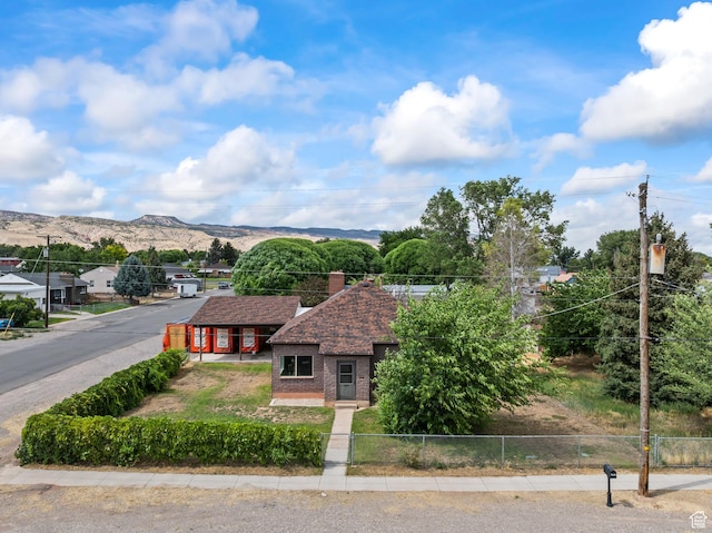 407 E 200 N, Richfield, UT 84701 - view of front of house featuring brick siding, a mountain view, roof with shingles, and a chimney