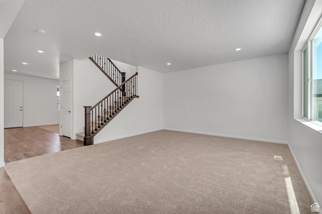 2123 N Wallflower Dr, Saratoga Springs, UT 84045 - unfurnished living room featuring carpet, recessed lighting, stairway, and a textured ceiling