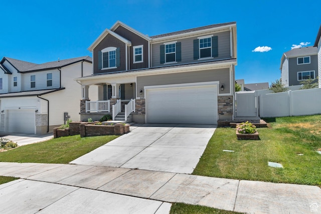 2123 N Wallflower Dr, Saratoga Springs, UT 84045 - view of front of house with a garage, covered porch, a gate, driveway, and stone siding