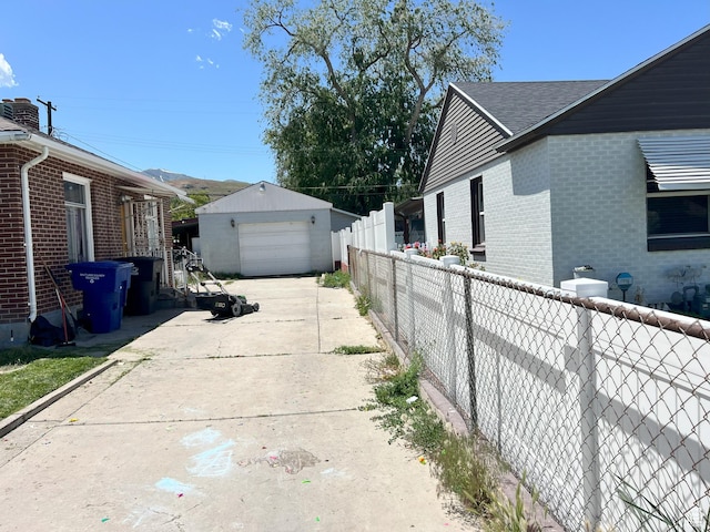 2980 S Merton Way, Magna, UT 84044 - view of property exterior with an outdoor structure, concrete driveway, brick siding, a detached garage, and a shingled roof