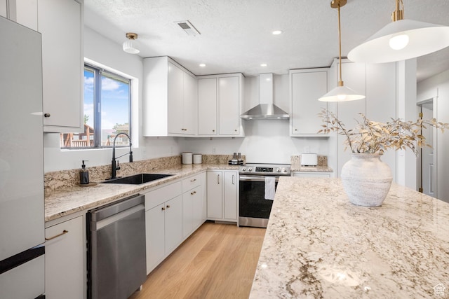 1655 Maplewood Way, St George, UT 84790 - kitchen with appliances with stainless steel finishes, wall chimney exhaust hood, light wood-type flooring, white cabinets, and recessed lighting