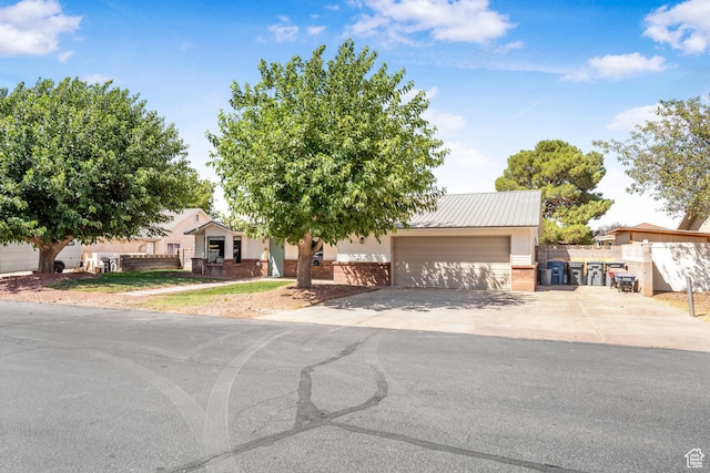 1655 Maplewood Way, St George, UT 84790 - obstructed view of property featuring a garage, concrete driveway, and brick siding