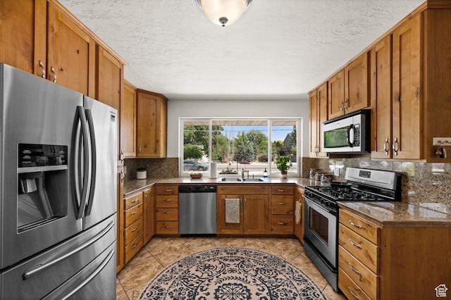 1770 E Vine St S, Salt Lake City, UT 84121 - kitchen with stainless steel appliances, brown cabinets, tasteful backsplash, dark countertops, and a textured ceiling