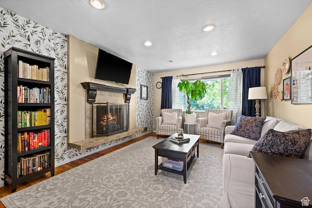 1770 E Vine St S, Salt Lake City, UT 84121 - living area with wallpapered walls, a tiled fireplace, wood finished floors, and recessed lighting