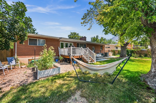 1770 E Vine St S, Salt Lake City, UT 84121 - rear view of house featuring brick siding, a wooden deck, a chimney, and a vegetable garden