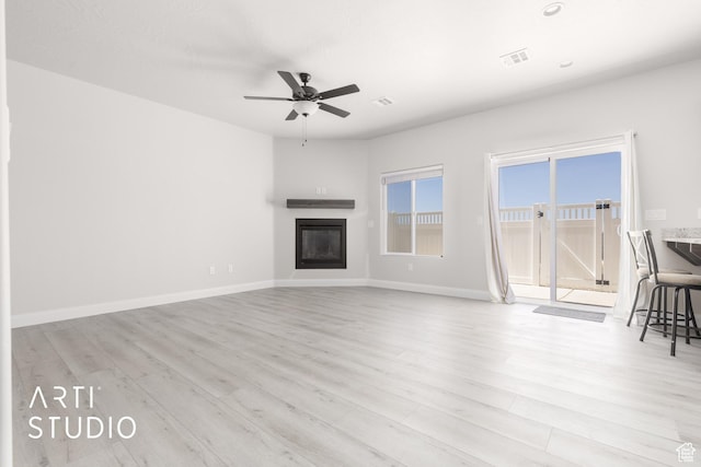 668 E Fiddlers Cove Dr Unit 35, Cedar City, UT 84721 - unfurnished living room with a glass covered fireplace, ceiling fan, and light wood finished floors