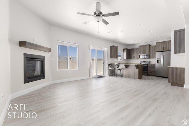 668 E Fiddlers Cove Dr Unit 35, Cedar City, UT 84721 - unfurnished living room with ceiling fan, light wood-style flooring, a glass covered fireplace, and recessed lighting