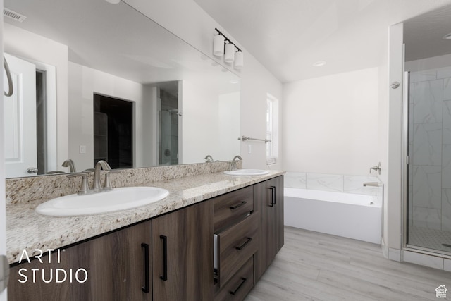 668 E Fiddlers Cove Dr Unit 35, Cedar City, UT 84721 - bathroom featuring double vanity, a bath, a stall shower, and wood finished floors