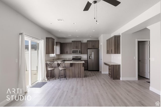668 E Fiddlers Cove Dr Unit 35, Cedar City, UT 84721 - kitchen with appliances with stainless steel finishes, a peninsula, a breakfast bar, light wood-style floors, and recessed lighting