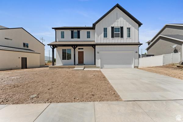 737 N Plainsman Dr Unit 108, Spanish Fork, UT 84660 - view of front of home with board and batten siding, a porch, an attached garage, and concrete driveway