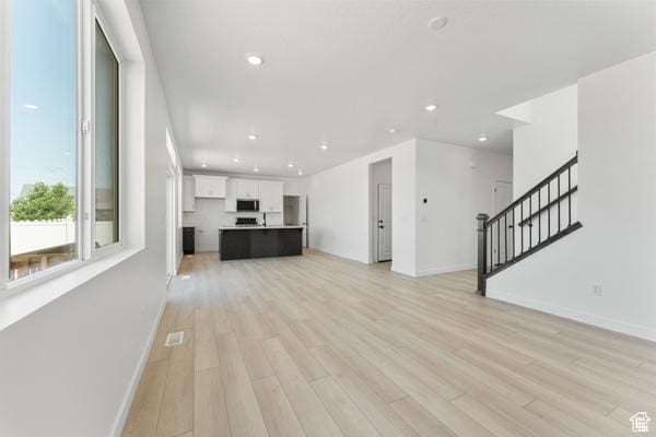 737 N Plainsman Dr Unit 108, Spanish Fork, UT 84660 - unfurnished living room featuring light wood-style floors, recessed lighting, and stairway