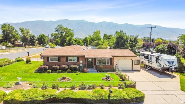 1632 Bennett St, Layton, UT 84041 - view of front of property with an attached garage, driveway, a mountain view, and brick siding