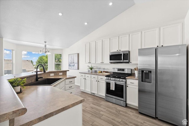 6515 S Mount Whitney Ln, West Valley City, UT 84118 - kitchen with stainless steel appliances, white cabinets, recessed lighting, light wood-style flooring, and a chandelier