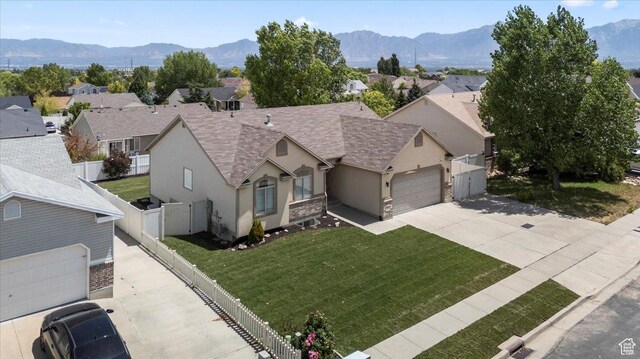 6515 S Mount Whitney Ln, West Valley City, UT 84118 - view of front of house with concrete driveway, a mountain view, an attached garage, and a residential view
