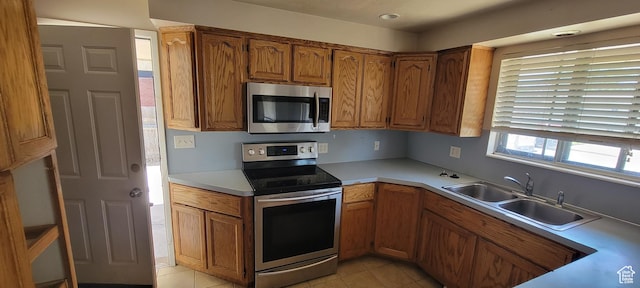 1226 N 450 W, Sunset, UT 84015 - kitchen featuring stainless steel appliances, brown cabinetry, light tile patterned flooring, and light countertops
