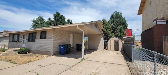1226 N 450 W, Sunset, UT 84015 - view of property exterior with a storage unit, brick siding, concrete driveway, and an attached carport