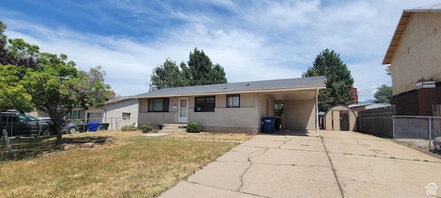 1226 N 450 W, Sunset, UT 84015 - view of front facade with a storage shed, driveway, a carport, and brick siding