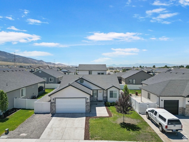 2362 E Quaking Aspen Ln, Eagle Mountain, UT 84005 - view of front facade with a residential view, a garage, stone siding, driveway, and a mountain view