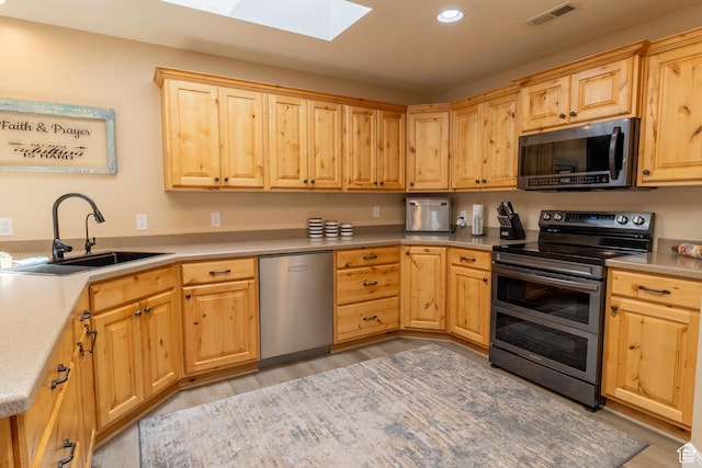594 W 5450 S, Riverdale, UT 84405 - kitchen featuring appliances with stainless steel finishes, a skylight, light wood-style flooring, light brown cabinets, and recessed lighting