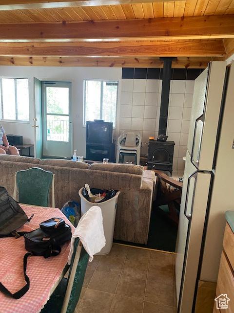 2160 S Aspen Ridge Dr, Coalville, UT 84017 - living area featuring a wood stove, a wood ceiling with exposed beams, and light tile patterned floors